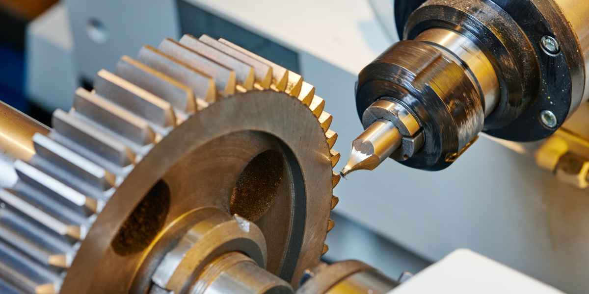 CNC machine tool axis drive where simple spur gears suit low-noise-budget designs